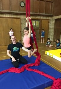 Student on silks with coach